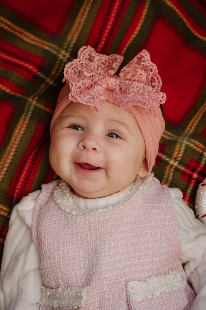 Weihnachts-Mini-Shooting Nordhausen – Baby mit rosa Schleife auf Schottenkaro-Decke