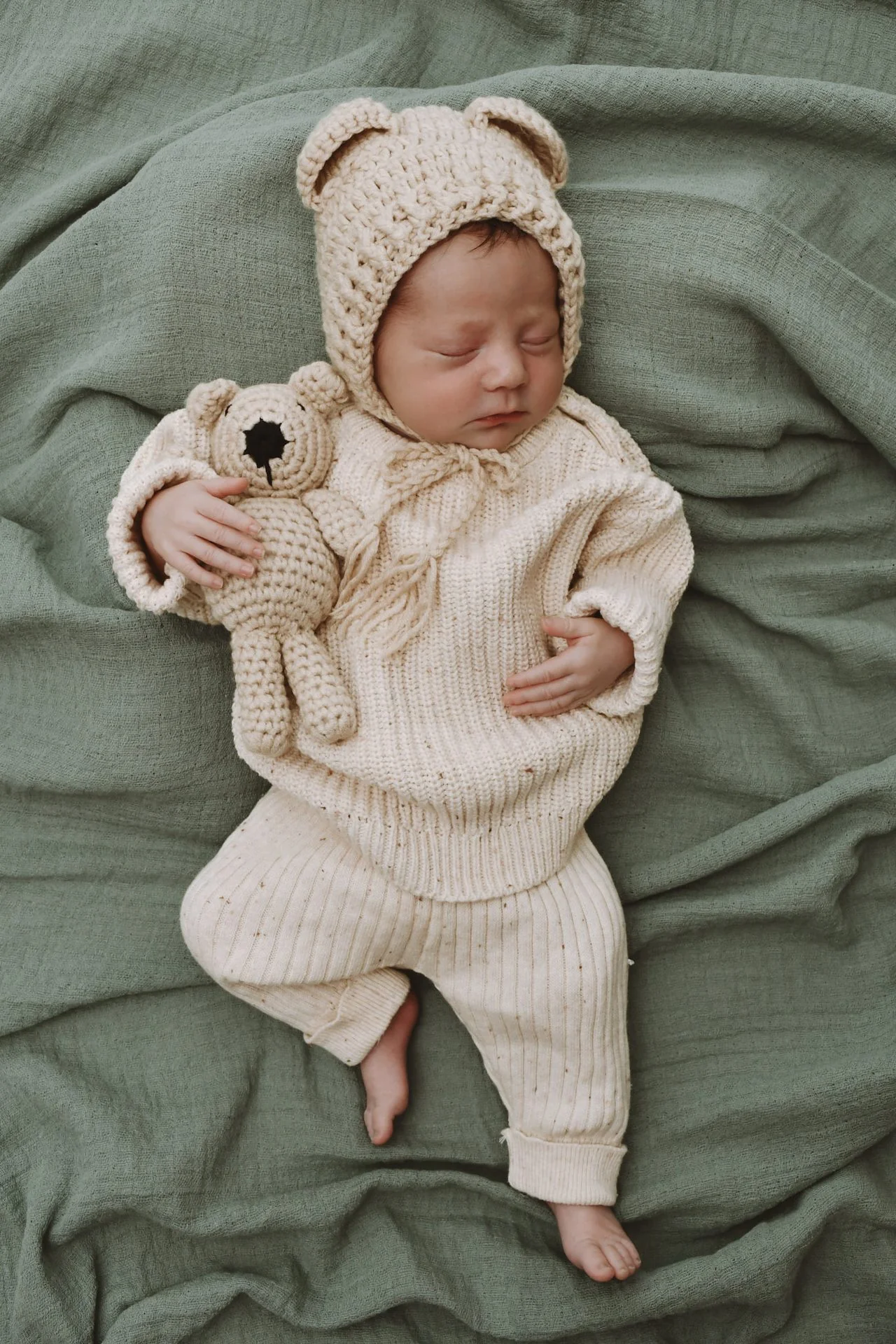 Newborn mit Bärmütze und Teddybär