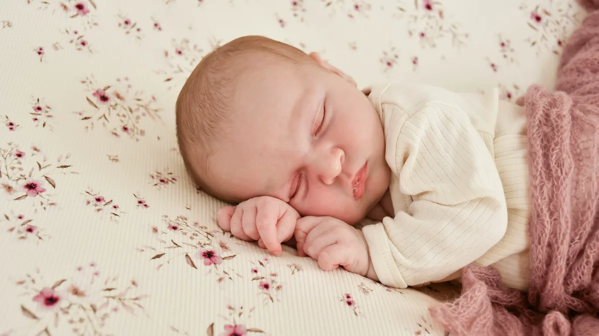 Newborn schläft friedlich vor Blumenhintergrund Nordhausen